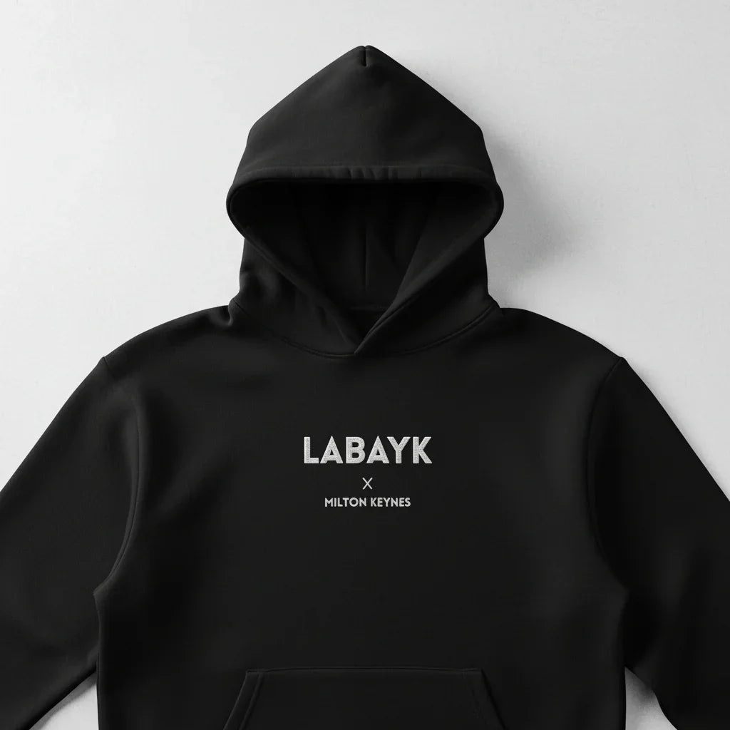 Front view of black minimalist hoodie with 'LABAYK x MILTON KEYNES' white text